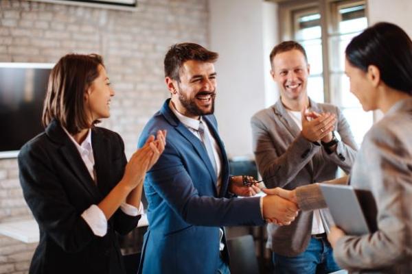 Un groupe de personne accueillant une nouvelle recrue