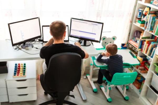 Père avec son enfant en télétravail. Travailler depuis chez soi.